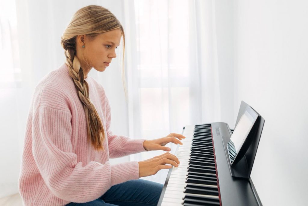 Jeune élève jouant du piano numérique lors d’un cours particulier en Belgique
