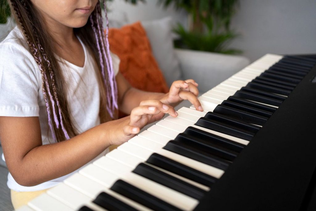Enfant jouant au piano numérique lors d’un cours particulier en Belgique