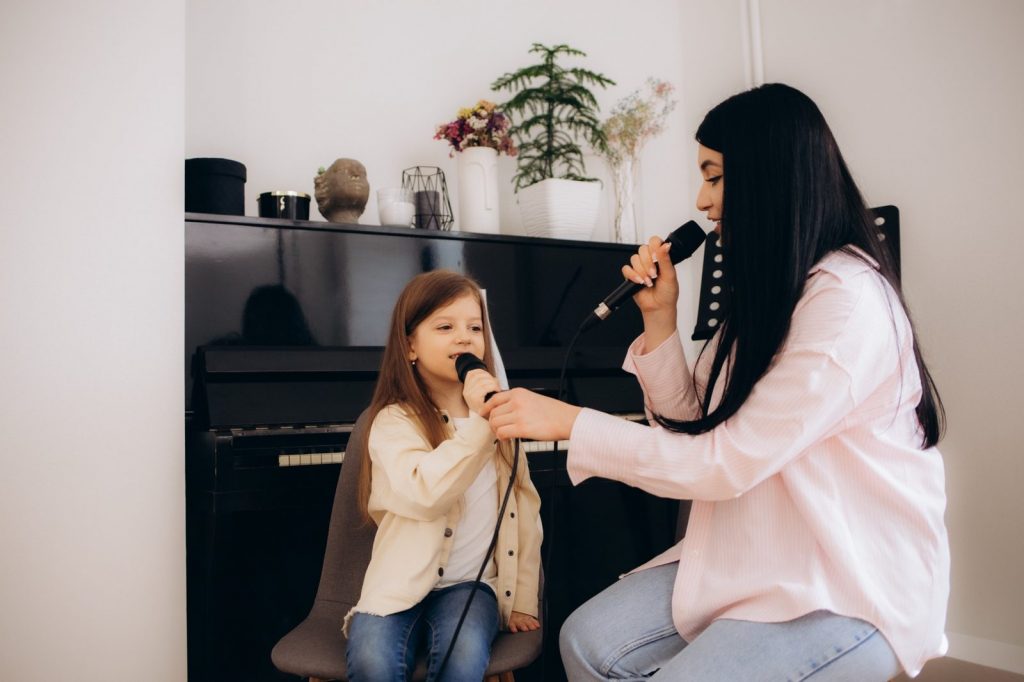 Cours de chant pour enfant à Bruxelles avec une professeure et une élève devant un piano