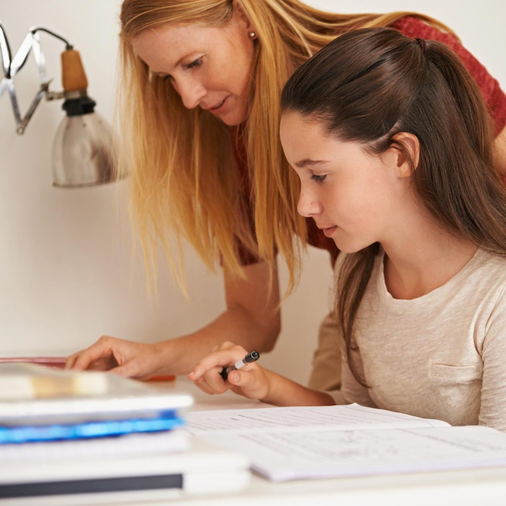 Professeur aidant une élève du secondaire pendant un cours de maths à Bruxelles